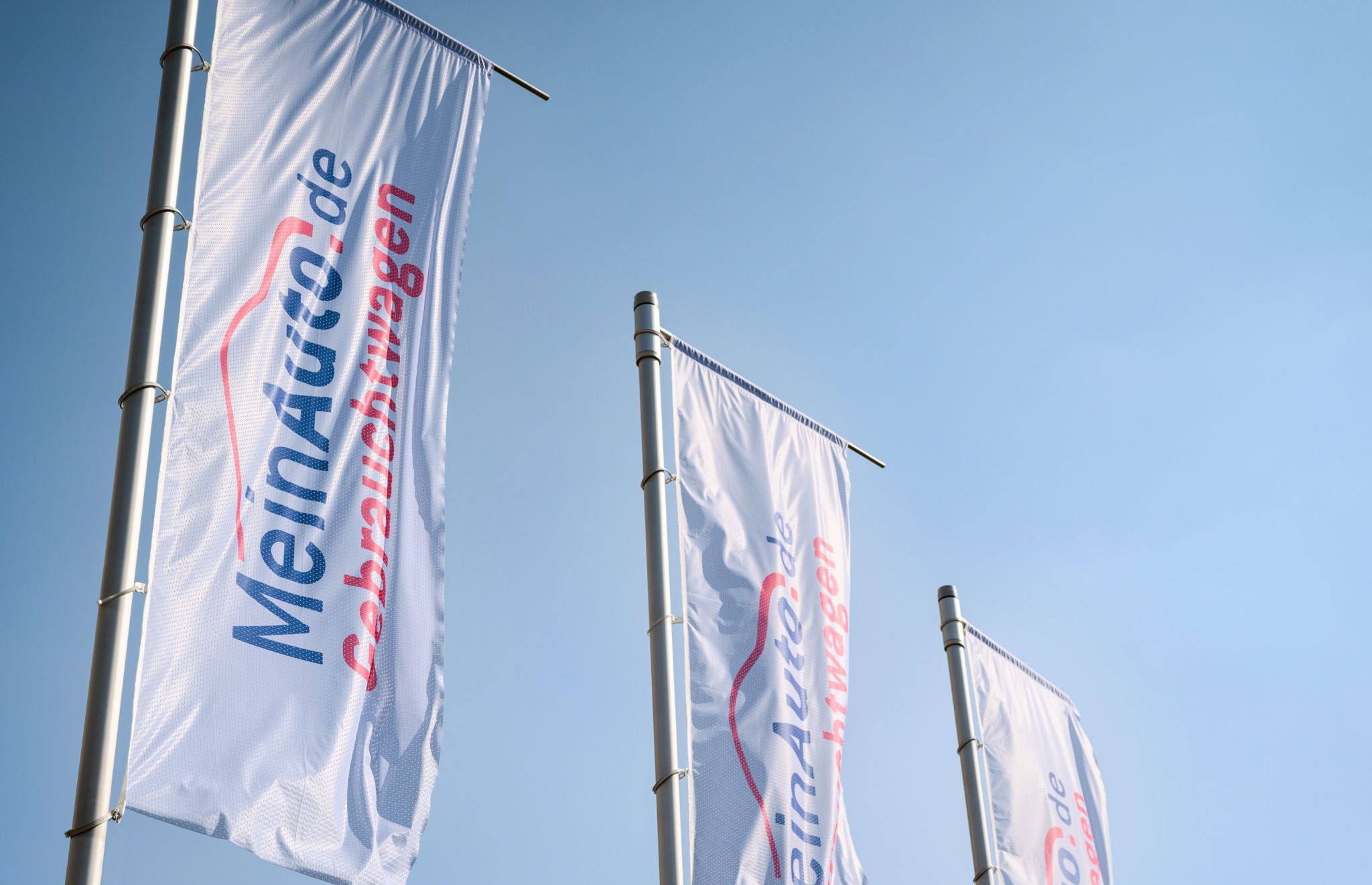 Drei Hissfahnen mit dem Logo von MeinAuto.de Gebrauchtwagen
